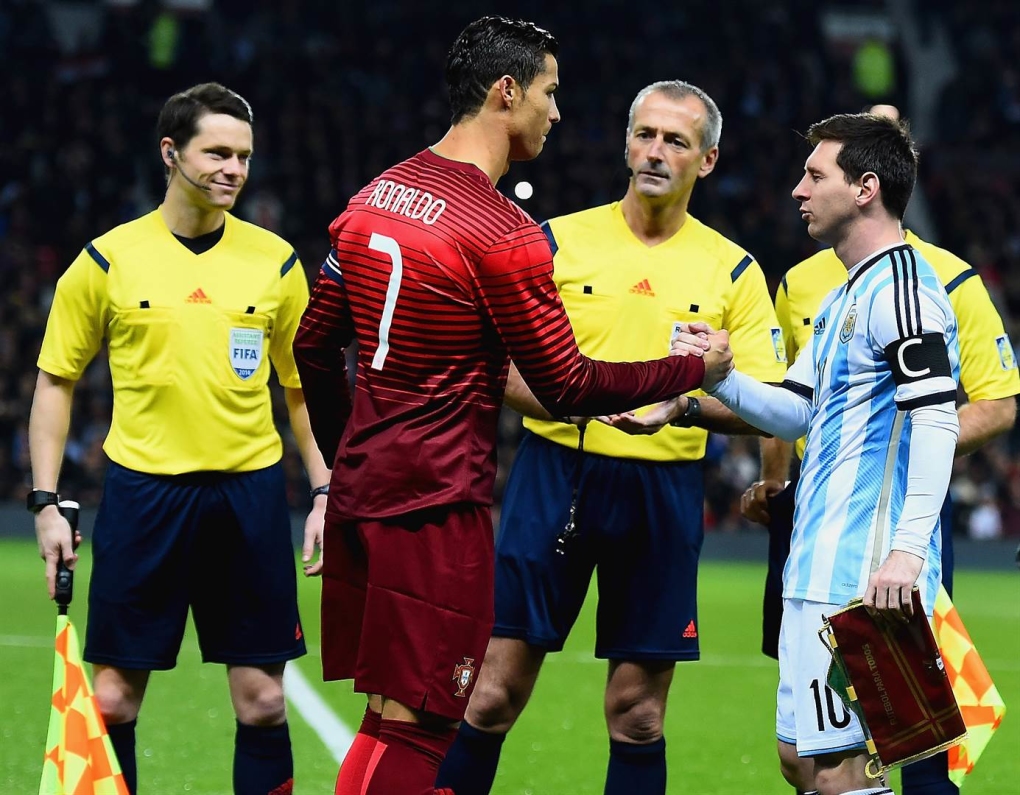 Messi và Ronaldo bắt tay nhau trên sân bóng năm 2014.